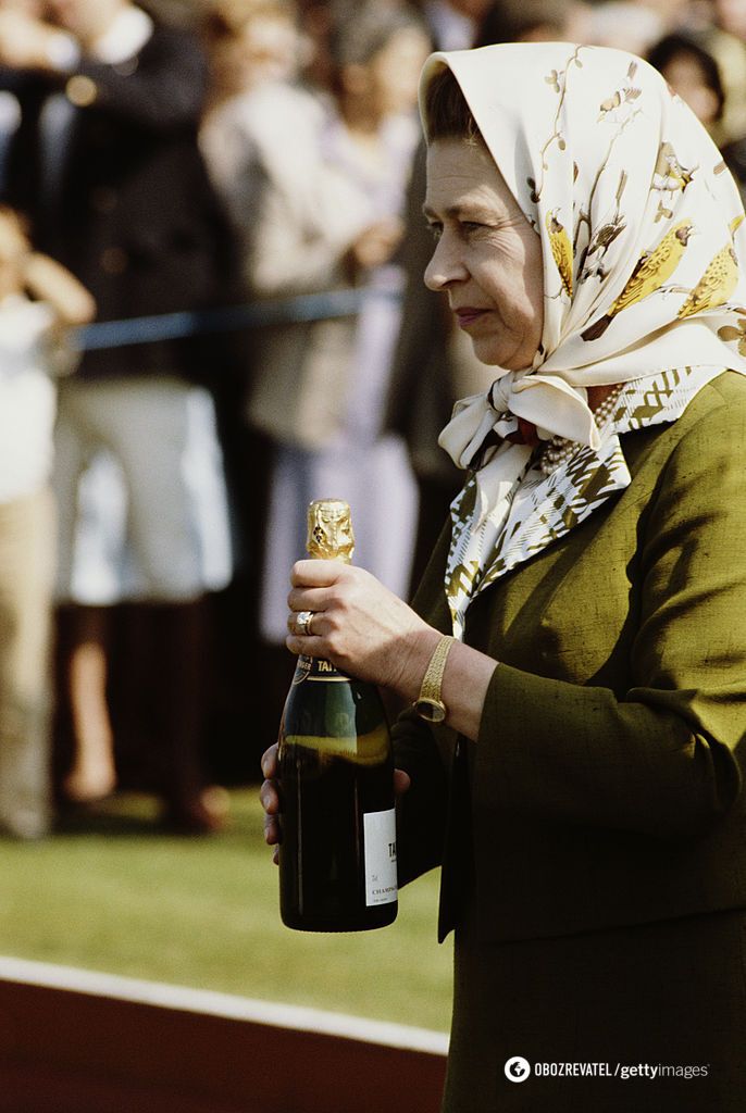 Королева Єлизавета II тримає пляшку шампанського на матчі по поло (1981).