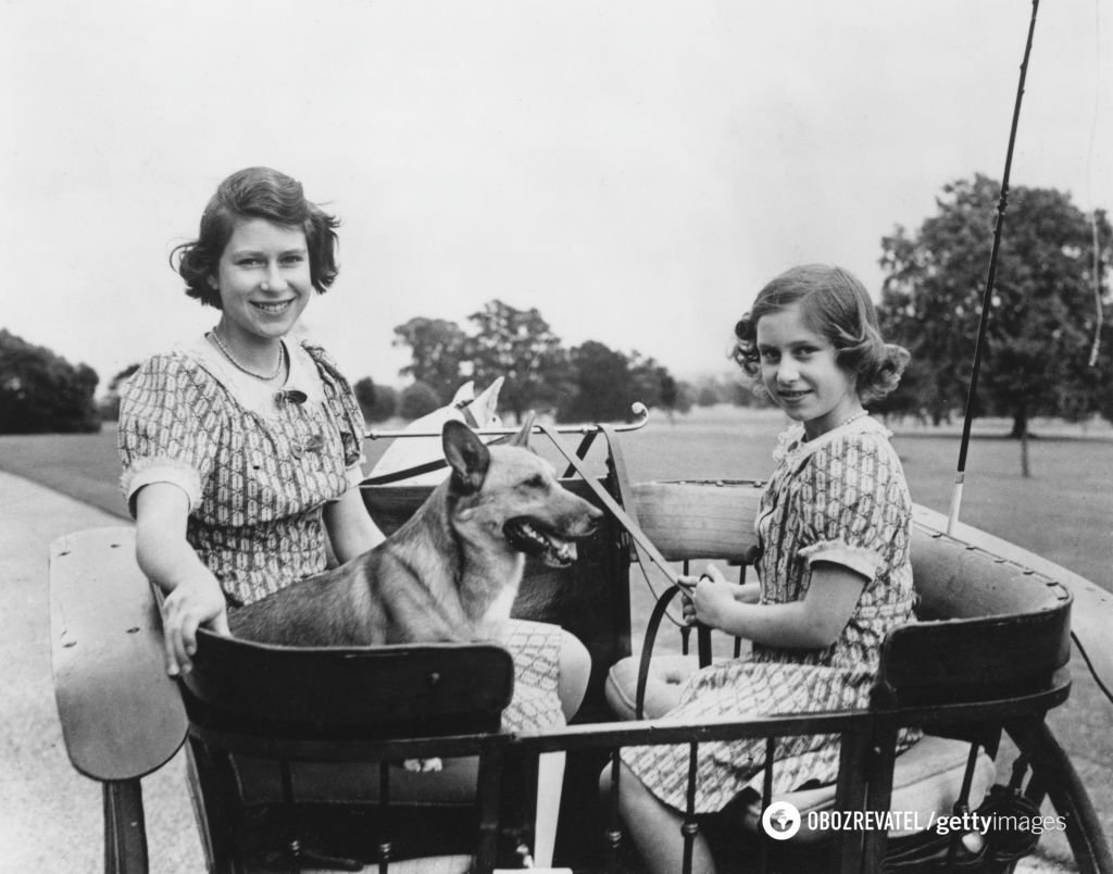 Принцеса Єлизавета (нині королева Єлизавета II, ліворуч) та її молодша сестра принцеса Маргарет Роуз сидять у кареті (Віндзорський парк, 1940).