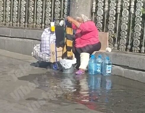 Жінка зливала воду під ноги пішоходам.